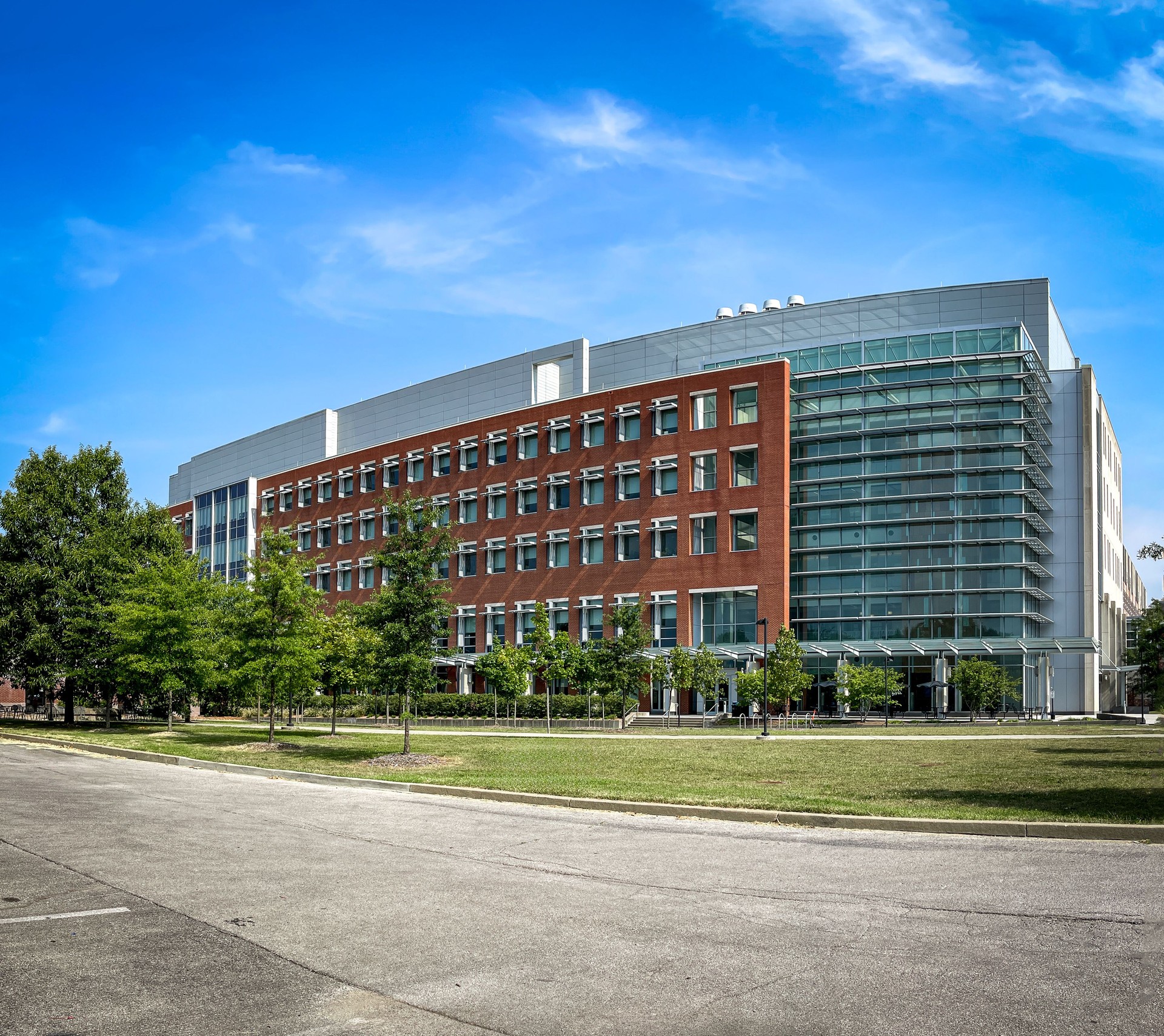 Modern architecture building as seen from a parking lot behind grass lawn