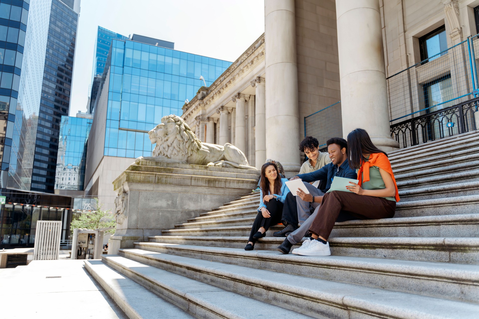 Students sharing ideas and using technology on university steps